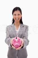 Piggy bank being held by businesswoman