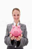 Piggy bank being offered by smiling bank employee