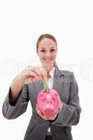 Money being put into piggy bank by smiling bank employee