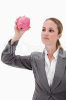 Bank employee taking close look at piggy bank