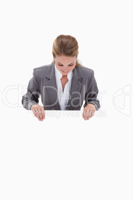 Bank employee looking down at blank sign in her hands