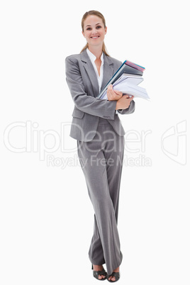 Smiling office employee with pile of paperwork