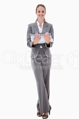 Smiling office employee holding pile of paperwork