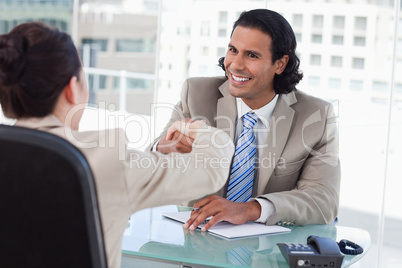 Manager shaking the hand of a female applicant