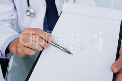 Close up of a male doctor showing a blank document