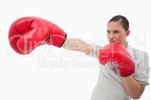 Businesswoman punching something with boxing gloves