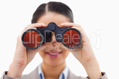 Close up of a businesswoman looking through binoculars