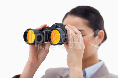 Brunette businesswoman looking through binoculars