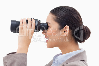 Side view of a businesswoman looking through binoculars