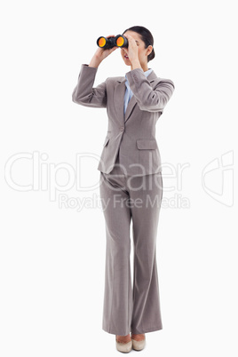 Portrait of a brunette businesswoman looking through binoculars