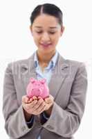 Portrait of a young businesswoman holding a piggy bank