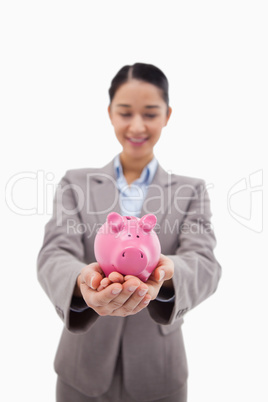 Portrait of a happy businesswoman holding a piggy bank