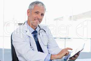 Smiling doctor working with a tablet computer