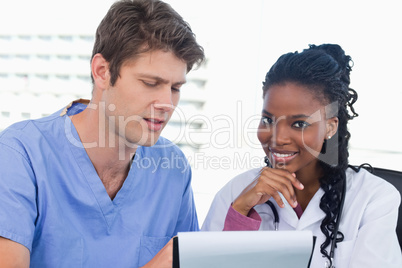 Smiling doctors looking at a document