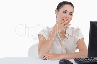 Exhausted businesswoman yawning while using a computer