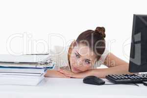 Tired secretary leaning on her desk