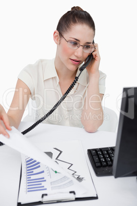 Portrait of a saleswoman making a phone call while looking at st