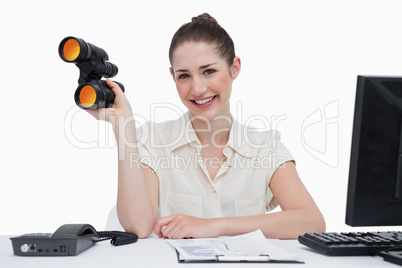 Smiling businesswoman holding binoculars