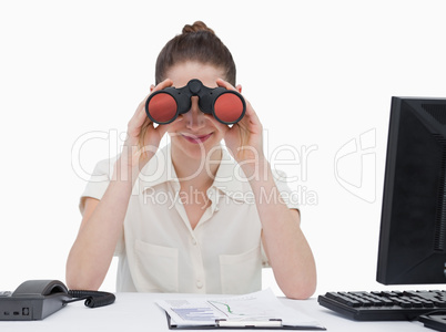 Businesswoman looking through binoculars