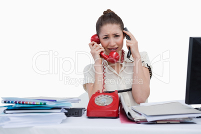 Overbooked businesswoman answering the phones