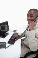 Side view of a male secretary answering the phone while using a