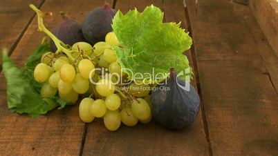 Green grapes and figs on wooden table