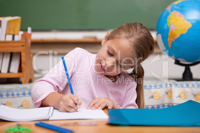 Happy schoolgirl writing