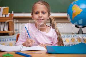 Smiling schoolgirl writing