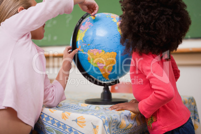 Schoolgirls pointing at a country