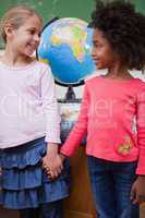 Portrait of smiling schoolgirls holding hands