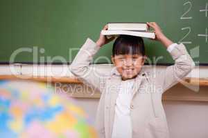 Schoolgirl holding her book on her head