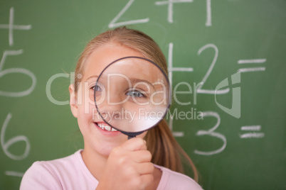 Schoolgirl looking through a magnifying glass