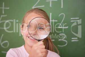 Schoolgirl looking through a magnifying glass