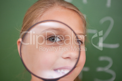 Close up of a schoolgirl looking through a magnifying glass