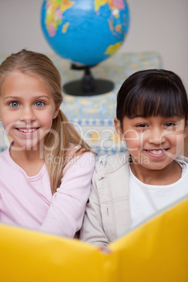 Portrait of happy schoolgirls reading