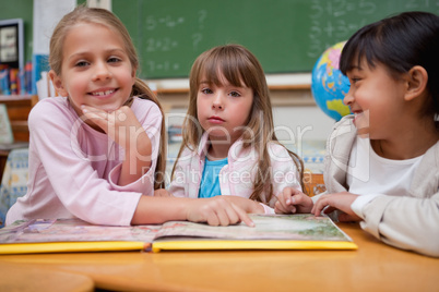 Schoolgirls reading a fairy tale to their classmate