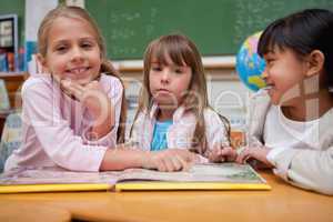 Schoolgirls reading a fairy tale to their classmate