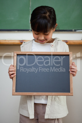 Portrait of a cute girl holding a school slate