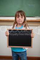 Portrait of a little girl holding a school slate