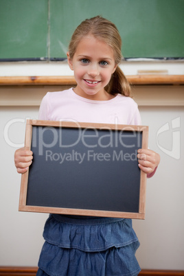 Portrait of a young girl holding at a school slate