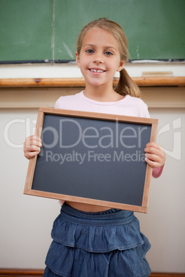 Portrait of a happy girl holding at a school slate