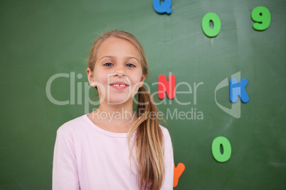 Schoolgirl posing in front of a blackboard