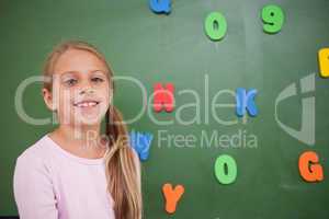 Young schoolgirl posing in front of a blackboard