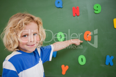 Schoolboy pointing at a letter