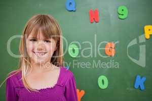 Little schoolgirl posing in front of a blackboard
