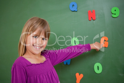 Little schoolgirl pointing at a letter