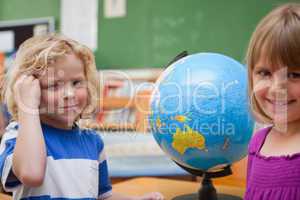 Pupils posing in front of a globe