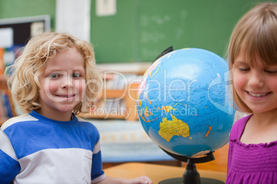 Young pupils posing in front of a globe