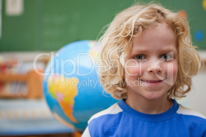 Schoolboy posing in front of a globe