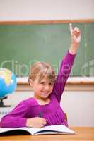Portrait of a schoolgirl raising her hand